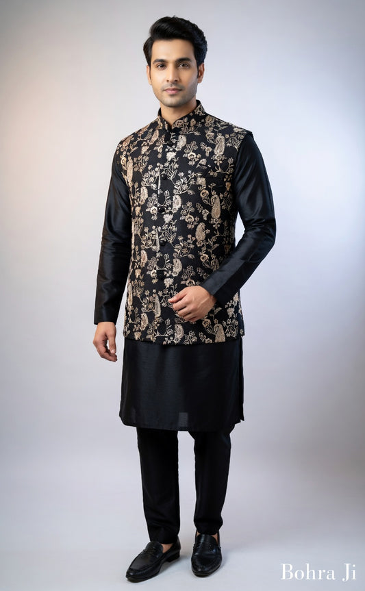Man wearing a black kurta with a patterned jacket on a white background