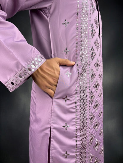 Close-up of a pink traditional outfit with intricate silver embroidery on a dark background