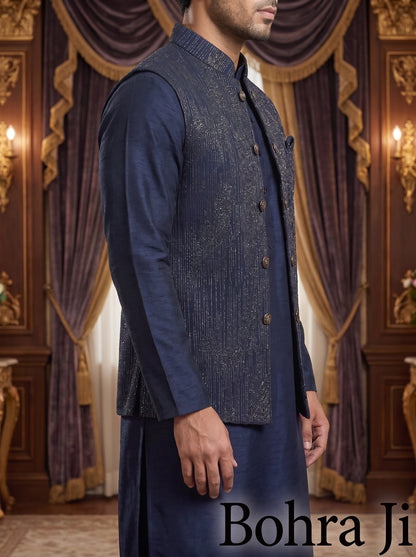 A man wearing a navy blue traditional outfit with a textured embroidered vest over a long-sleeve kurta, standing in an ornate room with purple drapery and gold wall decor. The text 'Bohra Ji' appears at the bottom right.
