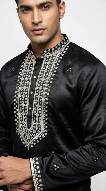 Man wearing a black embroidered shirt against a white background