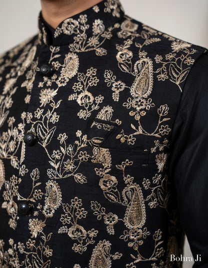 Black embroidered jacket with gold floral patterns on a plain background